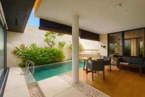 a house with a swimming pool and a dining room at Akhyana Village in Jimbaran +38 photos