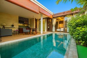 a swimming pool in front of a house at Akhyana Village in Jimbaran