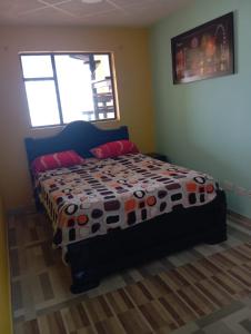 a bedroom with a bed with a colorful comforter at Club La Riviera in Ipiales