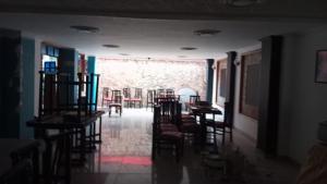 a hallway with chairs and tables in a room at Club La Riviera in Ipiales