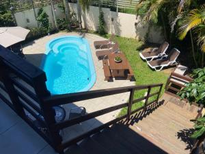 an overhead view of a swimming pool with chairs and a table at Pousada Casa Campeche - Floripa in Florianópolis
