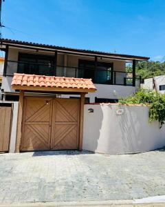 a house with a wooden garage with a gate at Chalés em Ilhabela 01 in Ilhabela