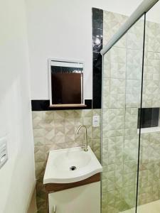 a bathroom with a sink and a glass shower at Chalés em Ilhabela 01 in Ilhabela +7 photos
