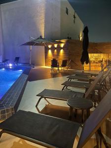 a pool with tables and chairs next to a building at Flat Executivo Intercity Manaus - Moderno e Aconchegante in Manaus