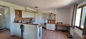 a kitchen with white cabinets and a table in it at Résidence Hirondelle Corrèze in Saint-Salvadour +10 photos