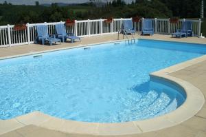 a large swimming pool with blue chairs at Résidence Hirondelle Corrèze in Saint-Salvadour