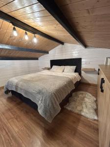 a bedroom with a large bed in a attic at Recele Tiny Nest in Ilva Mare
