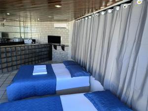 two beds with blue pillows in a room at Pousada Trip Inn Recife in Recife