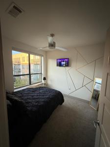 ダラスにあるDallas Loft-Your getaway homeのベッドと壁にテレビが掛かった寝室