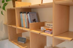 Una estantería llena de libros y un despertador. en Cozy Studio in Lahemaa National Park ! Perfect for Nature Lovers, en Kolga