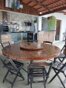 a large wooden table with chairs and a kitchen at Espaço d Lurdes in Piranhas +28 photos