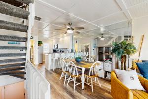 a dining room and kitchen with a table and chairs at Oceanfront Townhouse in Carolina Beach