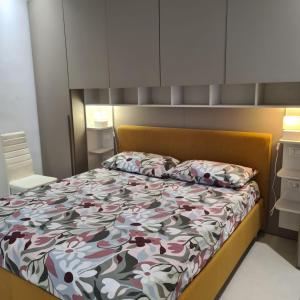 a bedroom with a bed with a floral comforter at RESIDENZA CORSO DALMAZIA in Civitanova Marche