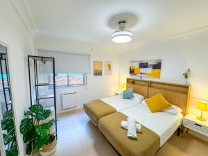 a bedroom with a large bed with yellow and blue pillows at El Ebro del Pilar - Turistea in Zaragoza +8 photos