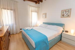 ein Schlafzimmer mit einem blauen Bett mit weißer Bettwäsche in der Unterkunft Venice Appartament Salini - Near the Biennale in Venedig