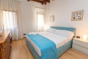 a bedroom with a blue bed with white sheets at Venice Appartament Salini - Near the Biennale in Venice
