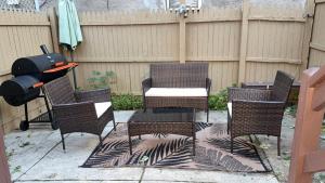 a patio with a grill and chairs and a table at Spacious Private Ensuite, With Private Bath, Outdoor Space, Workstation, Gym, & All Utilities Included in Point Breeze Home in Philadelphia