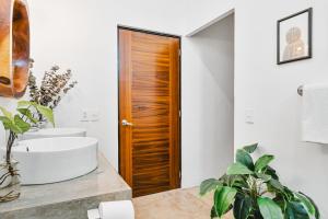 Un baño con puerta de madera y lavabo. en Downtown Casa Conchita Guest Suites, en Sayulita 38 fotos más