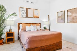 1 dormitorio con cama de madera y almohadas en Downtown Casa Conchita Guest Suites, en Sayulita
