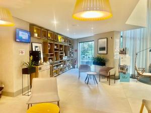 a living room with chairs and a table and a tv at Oscar Freire Confort in Sao Paulo