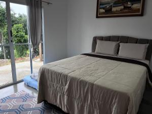 Un dormitorio con una cama y una ventana grande. en Sítio Bela Vista, en Angra dos Reis