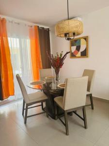 a dining room with a table and chairs and a chandelier at Acogedora y moderna Villa para vacacionar in Pueblo Bavaro