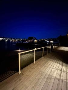 a wooden deck with a view of the water at night at Hytte med sjøen in Kristiansand