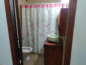 a bathroom with a sink and a toilet and a shower curtain at Lo de Charo in Miramar +10 photos