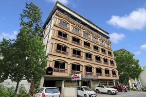 a tall building with cars parked in front of it at Townhouse OAK Hotel Belsons Taj Mahal in Hyderabad
