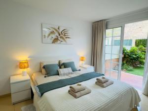 a bedroom with a large bed with towels on it at Bright Retreat with Lush Outdoor Space in Palm-Mar +24 photos