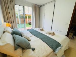a large bed in a room with a large window at Bright Retreat with Lush Outdoor Space in Palm-Mar