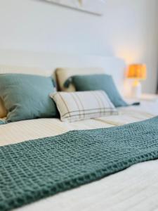 a close up of a bed with a green blanket on it at Bright Retreat with Lush Outdoor Space in Palm-Mar