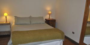 a bedroom with a bed and two lamps on tables at Azul House in Punta Arenas