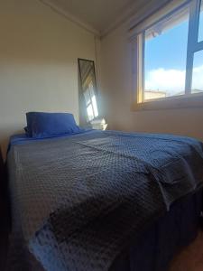 a bedroom with a bed with a large window at Azul House in Punta Arenas