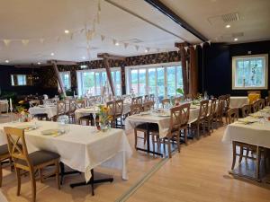 a dining room with white tables and chairs at Älgbergets Bed & Breakfast in Ucklum