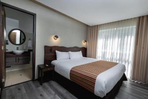 a hotel room with a large bed and a mirror at Hacienda del Valle Sagrado in Urubamba