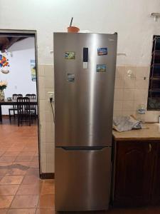 Un refrigerador de acero inoxidable con imanes en una cocina. en La Casa Siberia, en Encarnación