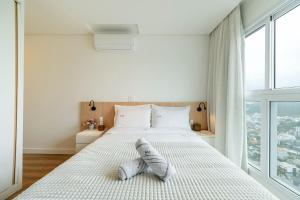 Ένα ή περισσότερα κρεβάτια σε δωμάτιο στο Riviera 2 Suítes e Piscina by Achei Camboriú +41 φωτογραφίες