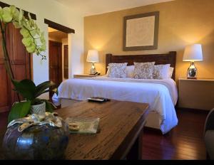 a bedroom with a large bed with a table and a table sidx sidx at Casa Aurea Hotel Boutique in Morelia