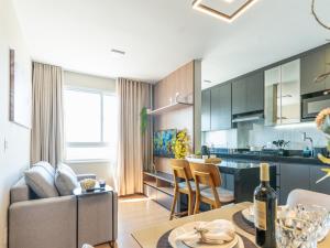 a kitchen and living room with a couch and a table at Apartamento sofisticado c vaga e vista Arena MRV in Belo Horizonte