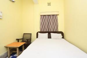 Un dormitorio con una cama y una mesa y una ventana. en Hotel O Surya, en Rourkela