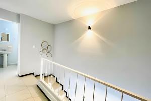 a white staircase with a light on the wall at Exclusive Place 10PX 8 Beds Wi-Fi Parking in Reynosa +42 photos