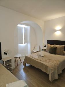 a bedroom with a large bed and an arched doorway at Alcamim Guesthouse in Elvas