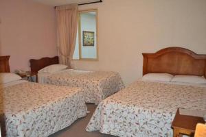 a hotel room with two beds and a mirror at Azul House in Punta Arenas