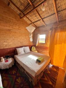 une chambre avec un grand lit dans une pièce dans l'établissement Mbin Maak du Saloum, à Mar Lodj