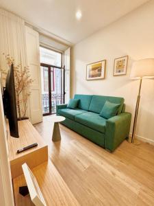 a living room with a green couch and a television at Douro Views by MyMoradia in Porto