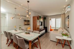 a dining room and living room with a table and chairs at Ótima localização - @stayhousetemporada in Canela