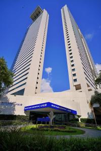 two tall buildings with a blue sky in the background at Beach Class Convention By MAI in Recife