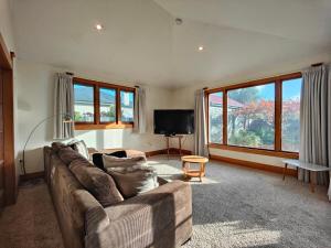 a living room with a couch and a television at Heritage & Heart by the Park in Invercargill