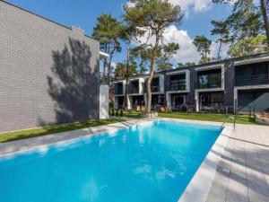 a swimming pool in front of a building at Comfortable holiday home with garden, summer pool in Pobierowo